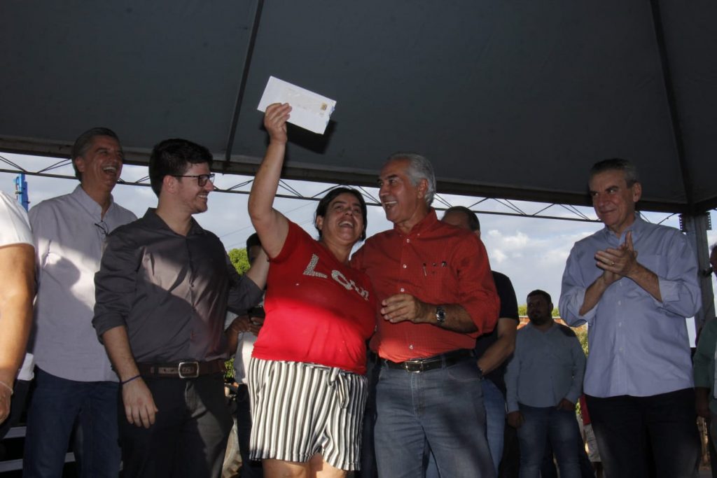 Ao lado do prefeito José Natan e do governador Reinaldo Azambuja, moradora de Aparecida do Taboado comemora o recebimento do cartão do Mais Social